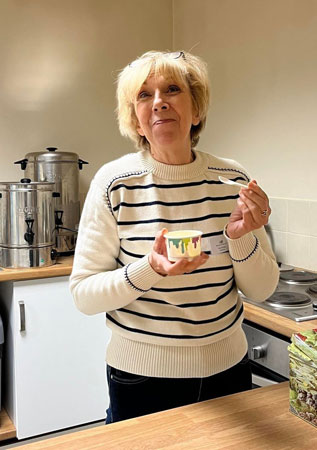 A lady smiles as she eats ice cream