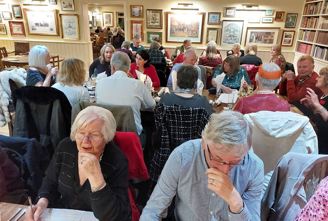 People sitting at tables puzzle over a quiz
