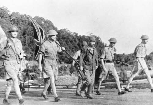 Lieutenant-General Arthur Percival and his party carry the Union Jack on their way to surrender Singapore to the Japanese, 15 February 1942 © IWM HU 2781