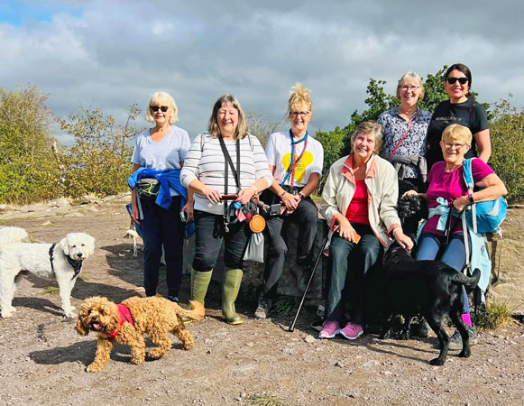 Seven members and four dogs sit or stand to pose for the camera